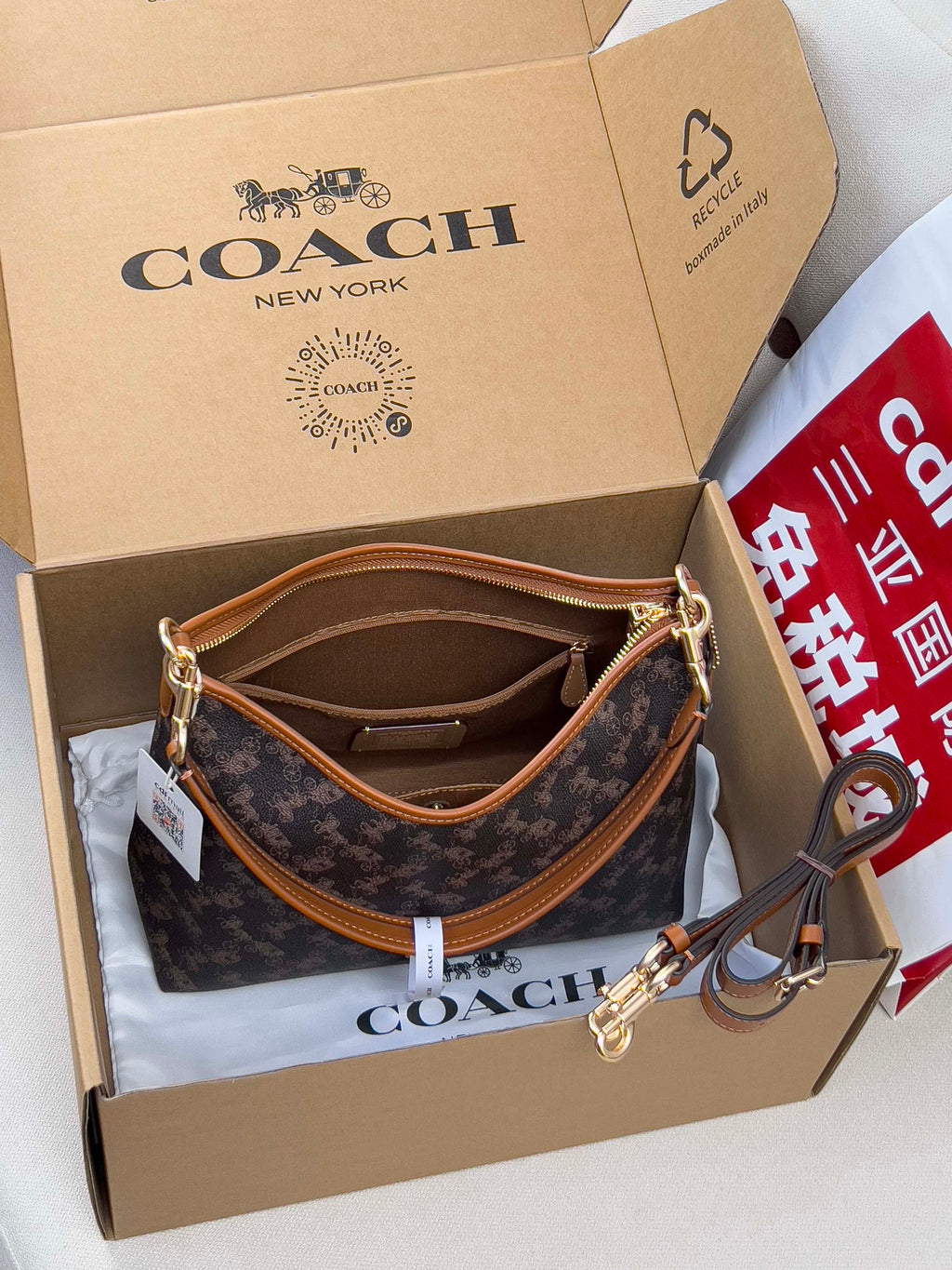 Coah monogram crossbody bag with tan strap and gold-tone clasp hardware
