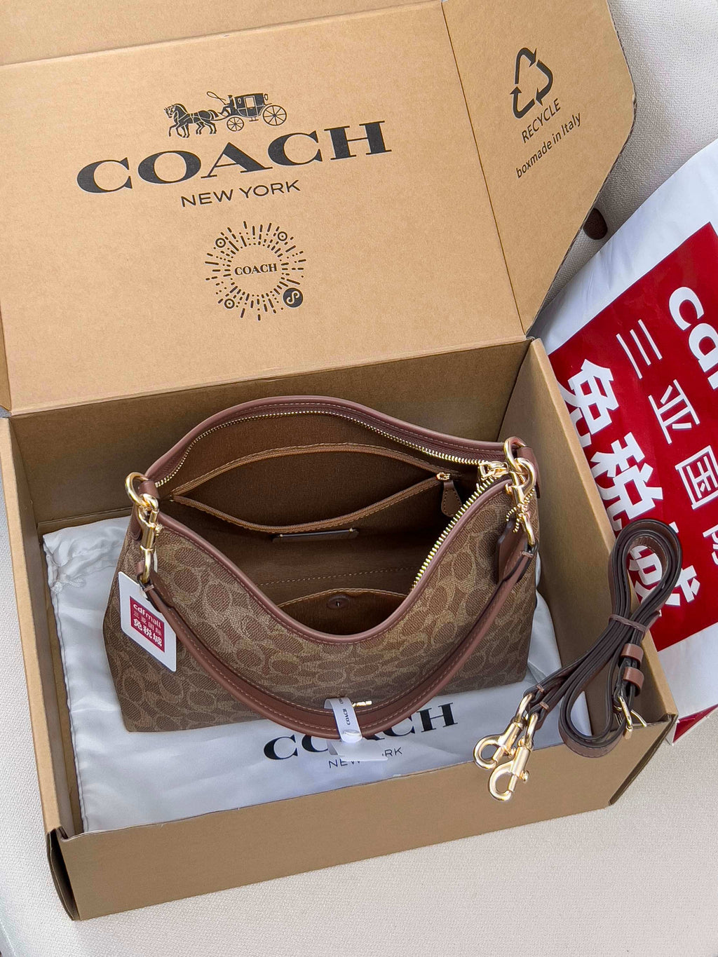 Brown monogram hobo bag with top zip, chain strap, and gold-tone hardware