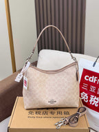 Coah shoulder bag on gift box, light beige monogram canvas, curved handle and hang tags