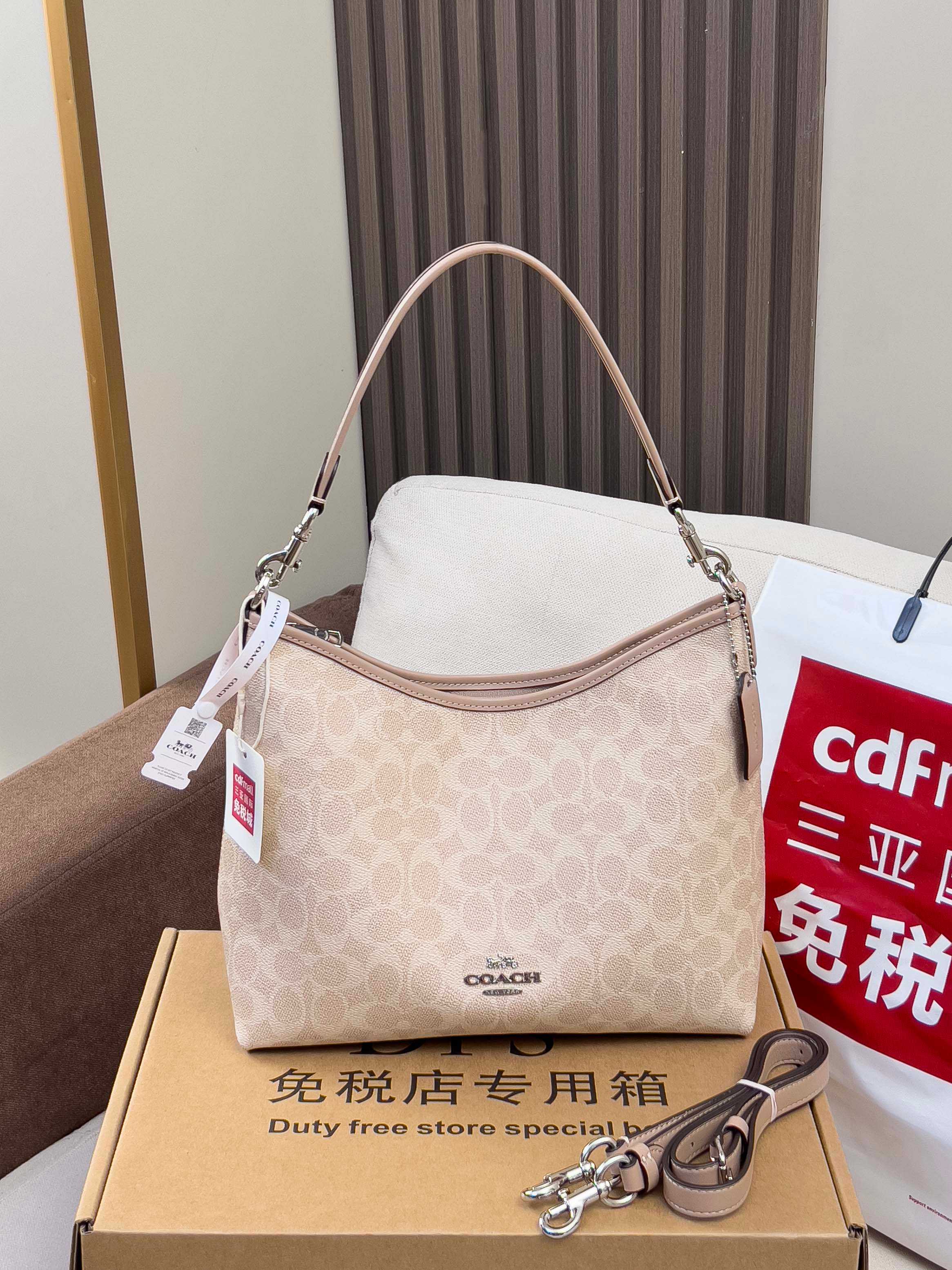 Coah shoulder bag on gift box, light beige monogram canvas, curved handle and hang tags