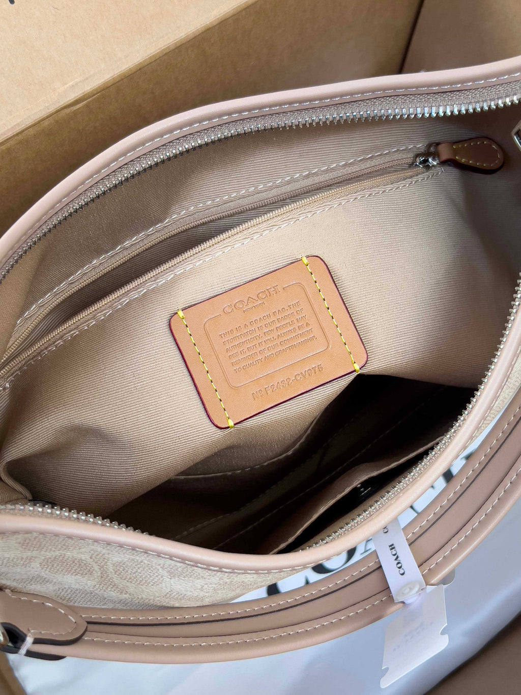 Coah bag interior leather patch close-up, light beige lining and zipper track
