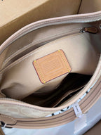 Coah bag interior leather patch close-up, light beige lining and zipper track