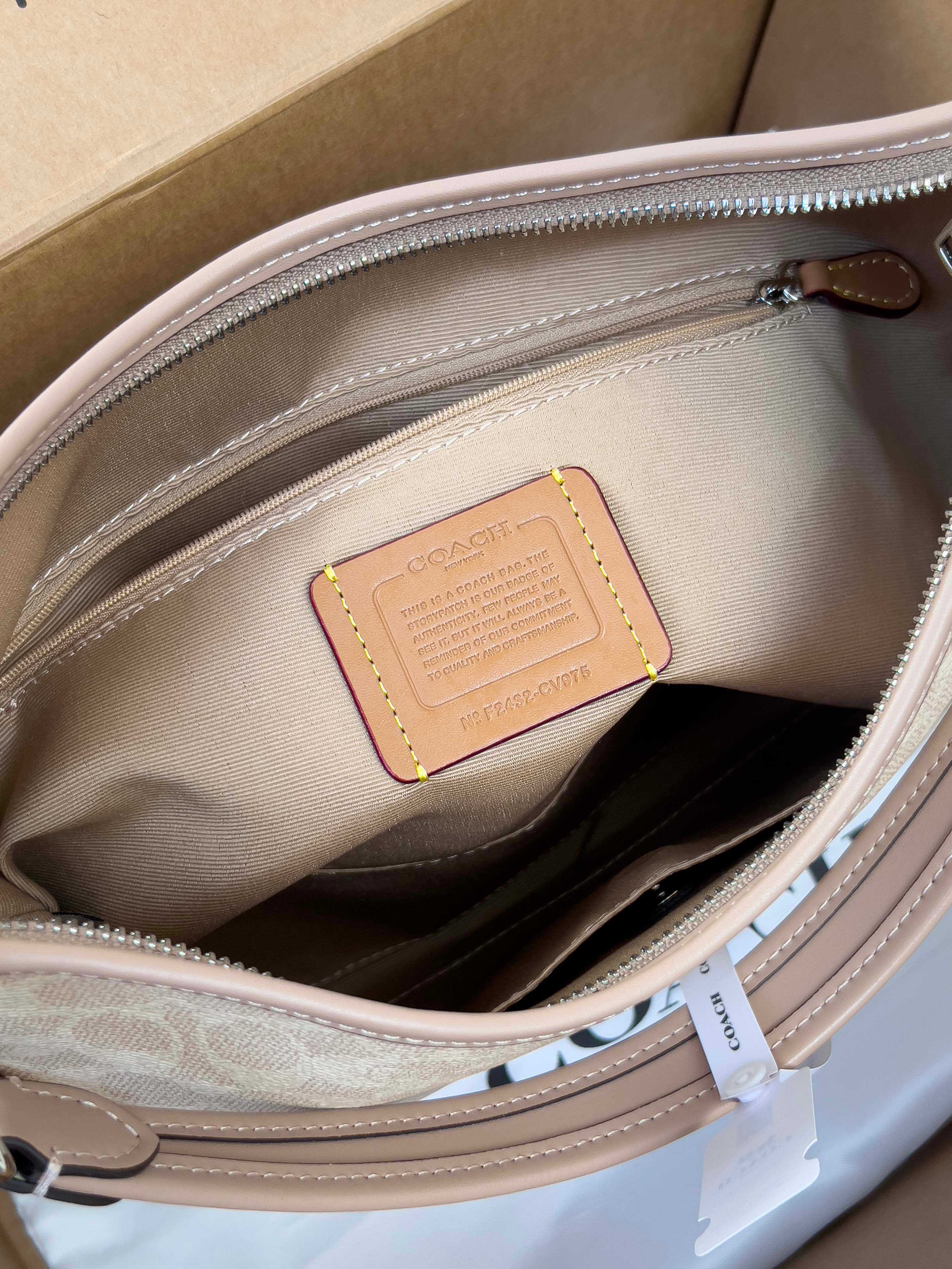 Coah bag interior leather patch close-up, light beige lining and zipper track