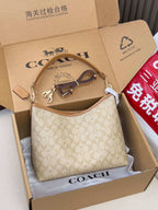 Coach signature mini shoulder bag, light tan monogram, top zip and tan leather strap.