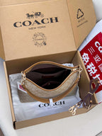 Coach signature hobo bag, light tan monogram, open top with gold-tone zipper and handles.