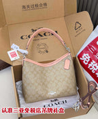 Beige monogram hobo bag with pink handles and zip closure