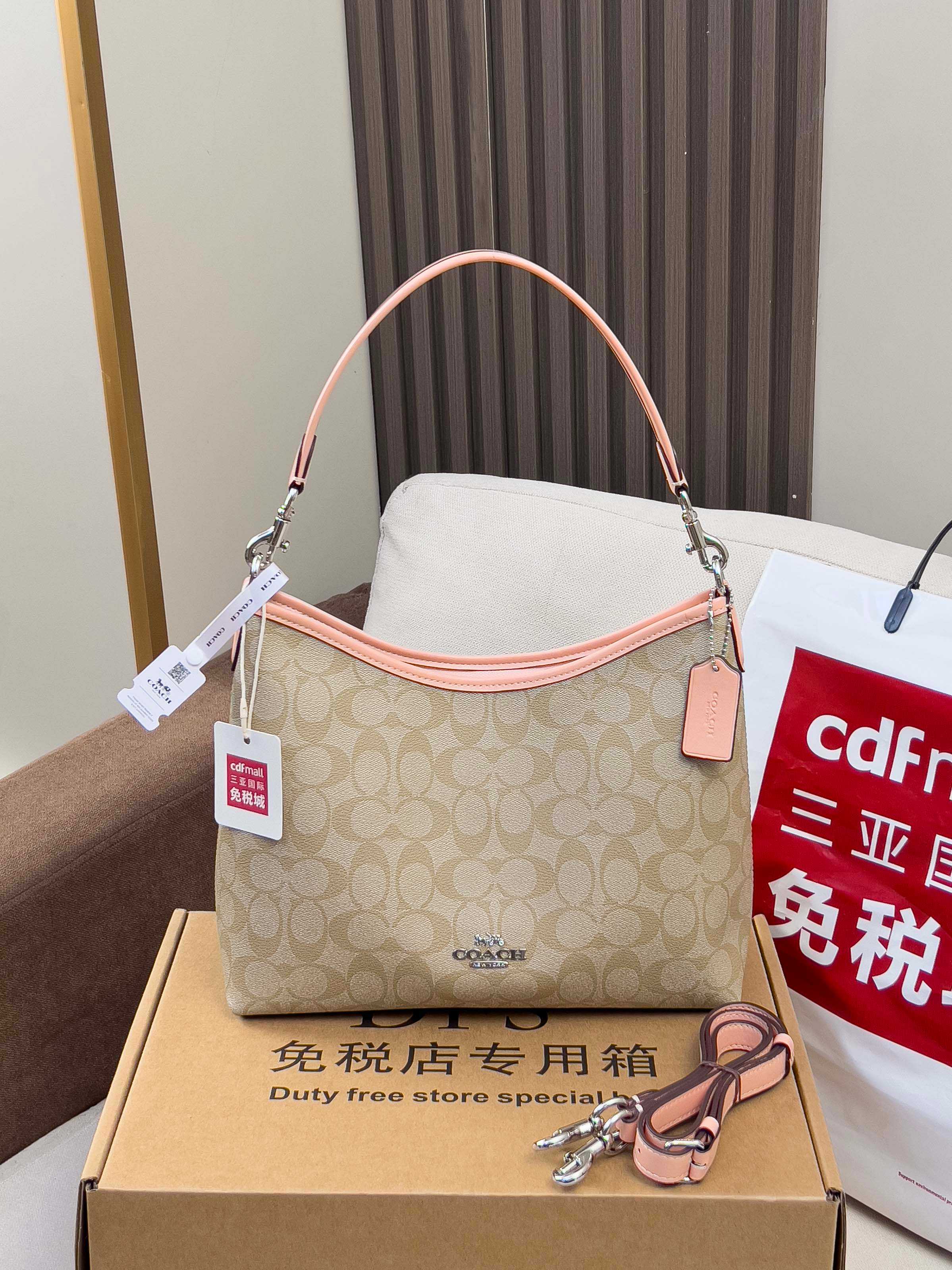 Beige monogram hobo bag with pink handles and hanging charm