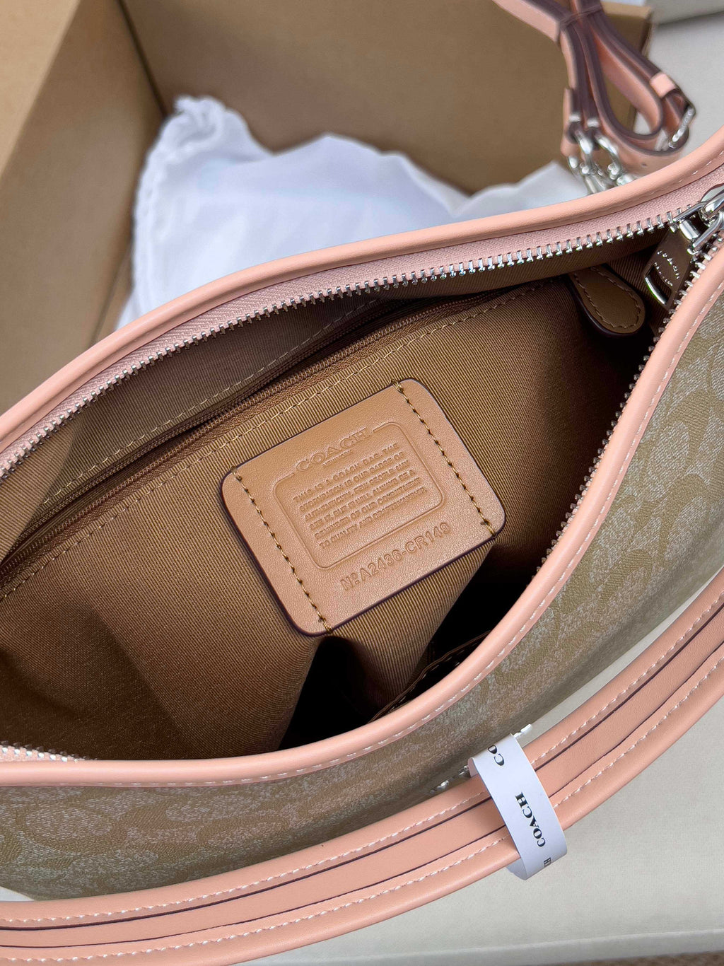 Interior view of beige monogram bag with brown lining and pink trim
