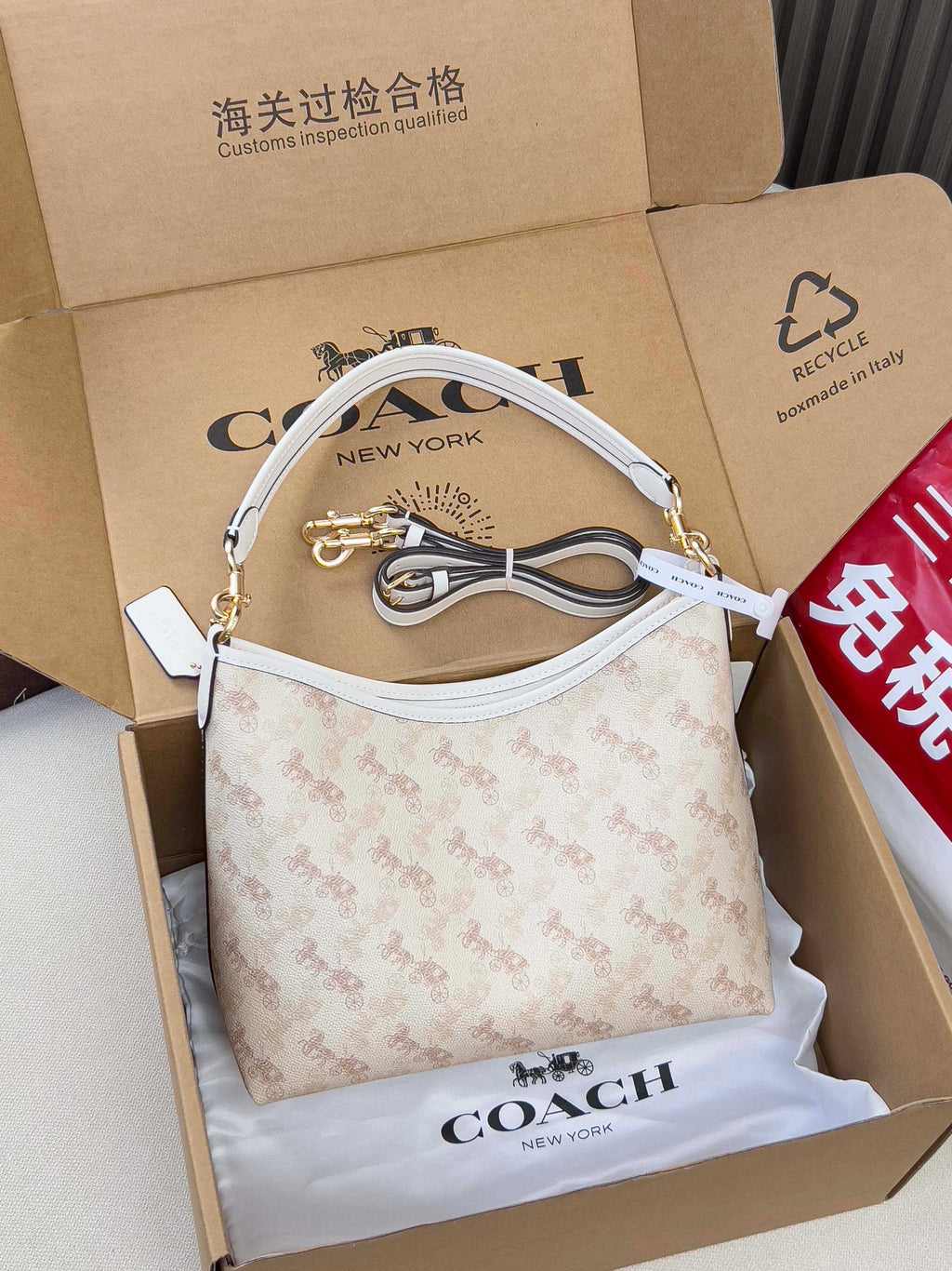 Light beige patterned handbag with white strap, gold hardware, and bow charm