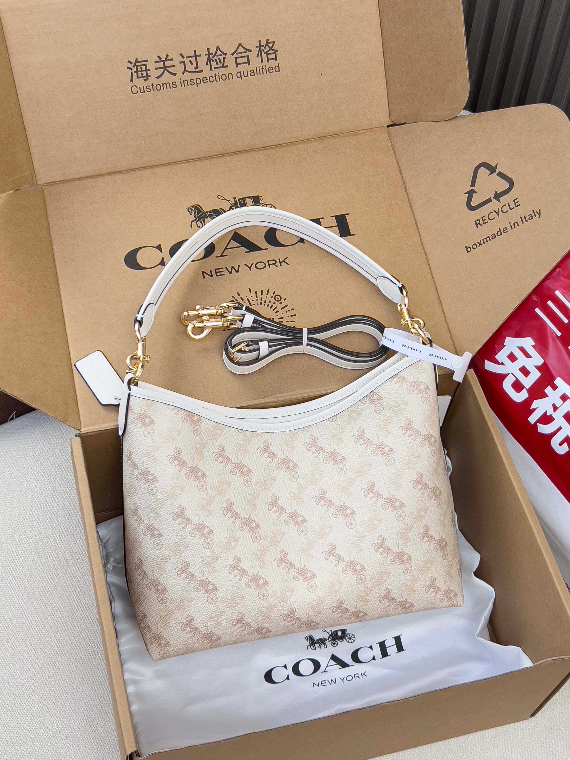 Light beige patterned handbag with white strap, gold hardware, and bow charm
