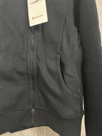 Dark zip-up hooded jacket close-up of front zipper and side pocket opening