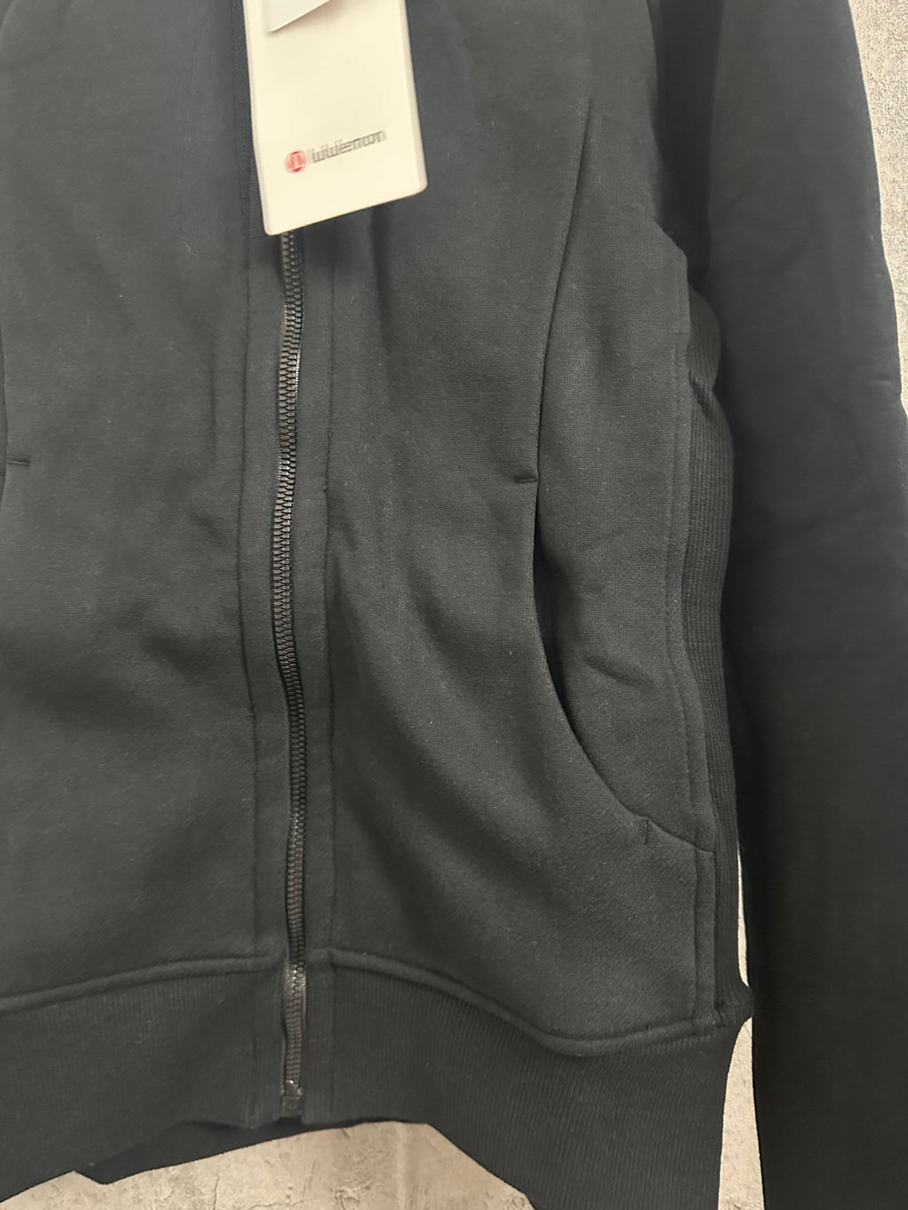 Dark hoodie front with visible zipper and stitched seams