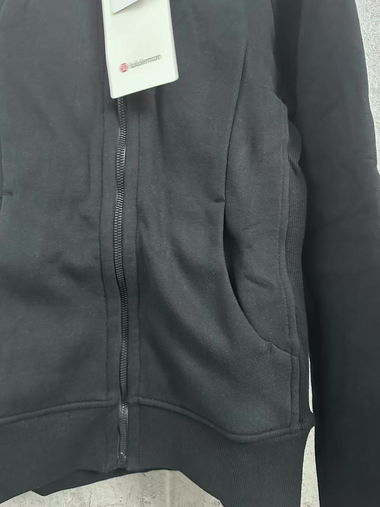 Dark hoodie zipper placket with curved pocket seam detail