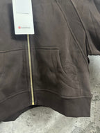 Dark zip-up hoodie front pocket area with gold zipper