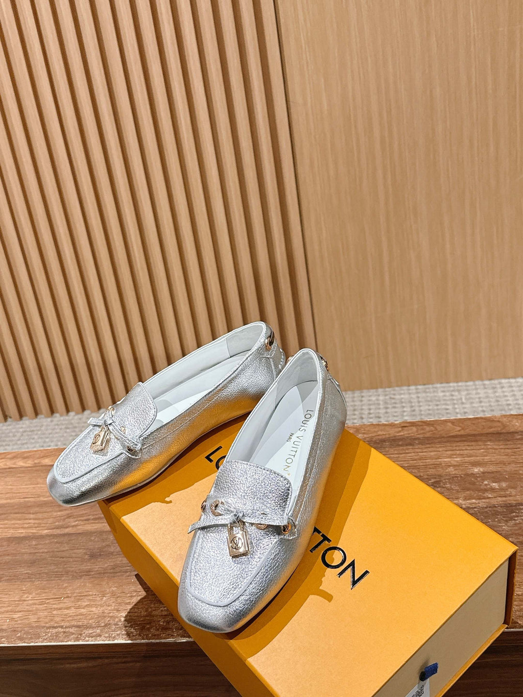 Silver metallic loafers with gold-tone buckle and lightly textured leather finish