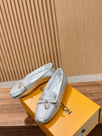 Silver metallic loafers with gold-tone buckle and lightly textured leather finish