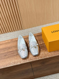 Silver metallic leather loafers with gold-tone buckle detail on the vamp