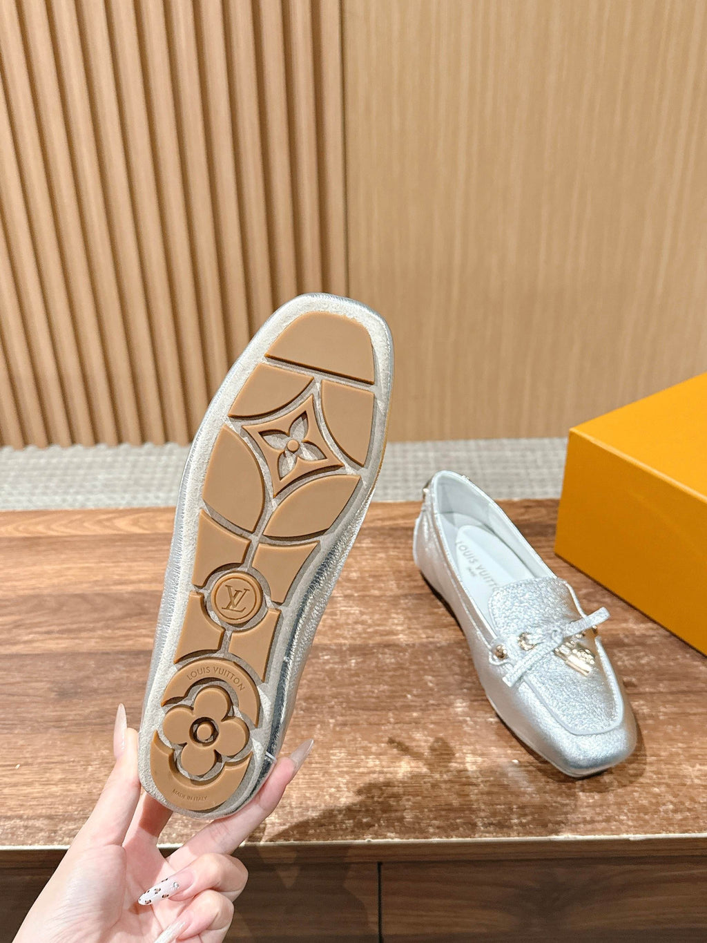 Silver metallic loafer outsole with embossed floral logo pattern