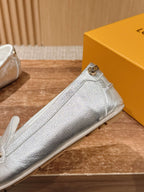 Silver metallic loafer side view with gold-tone buckle strap and stitched seams