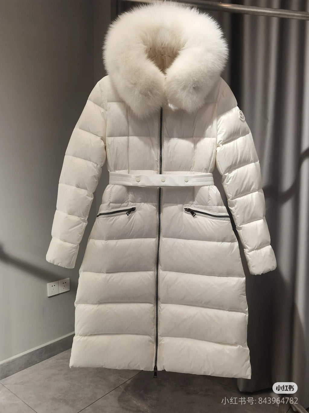 Long white puffer coat with faux fur hood and waist belt, quilted panels