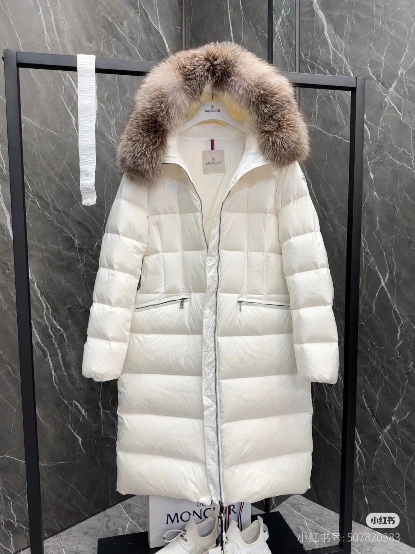 Long white puffer coat with faux fur hood, front zipper, flap pockets