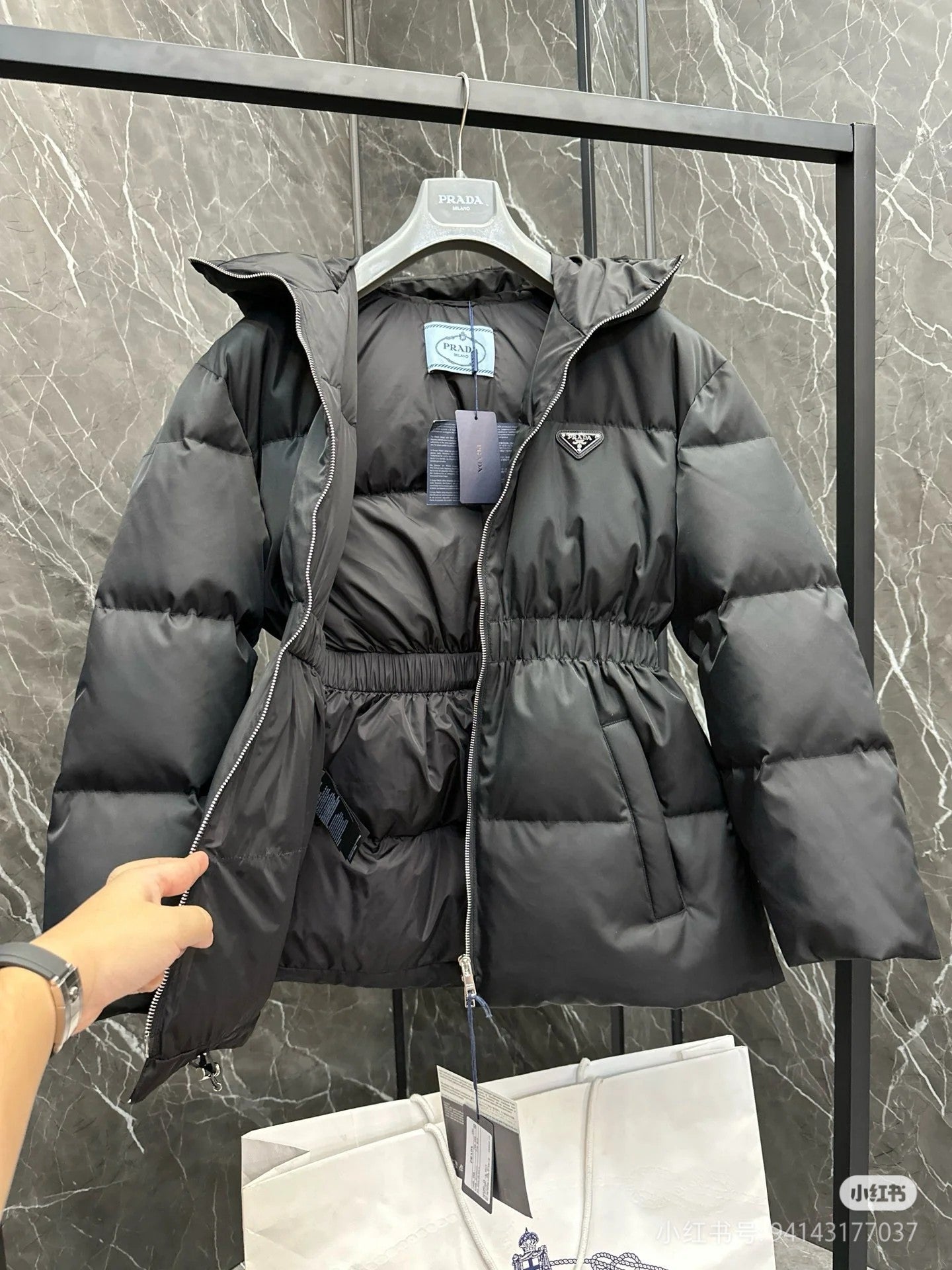 Dark puffer jacket with hood, full zip, cinched waist, logo patch
