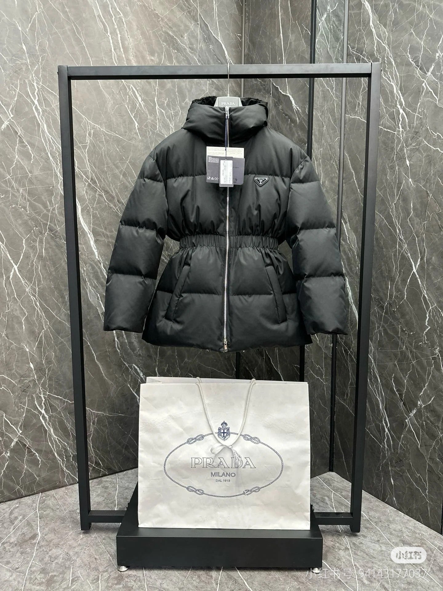 Black hooded puffer jacket with full zip and elastic waist, front view