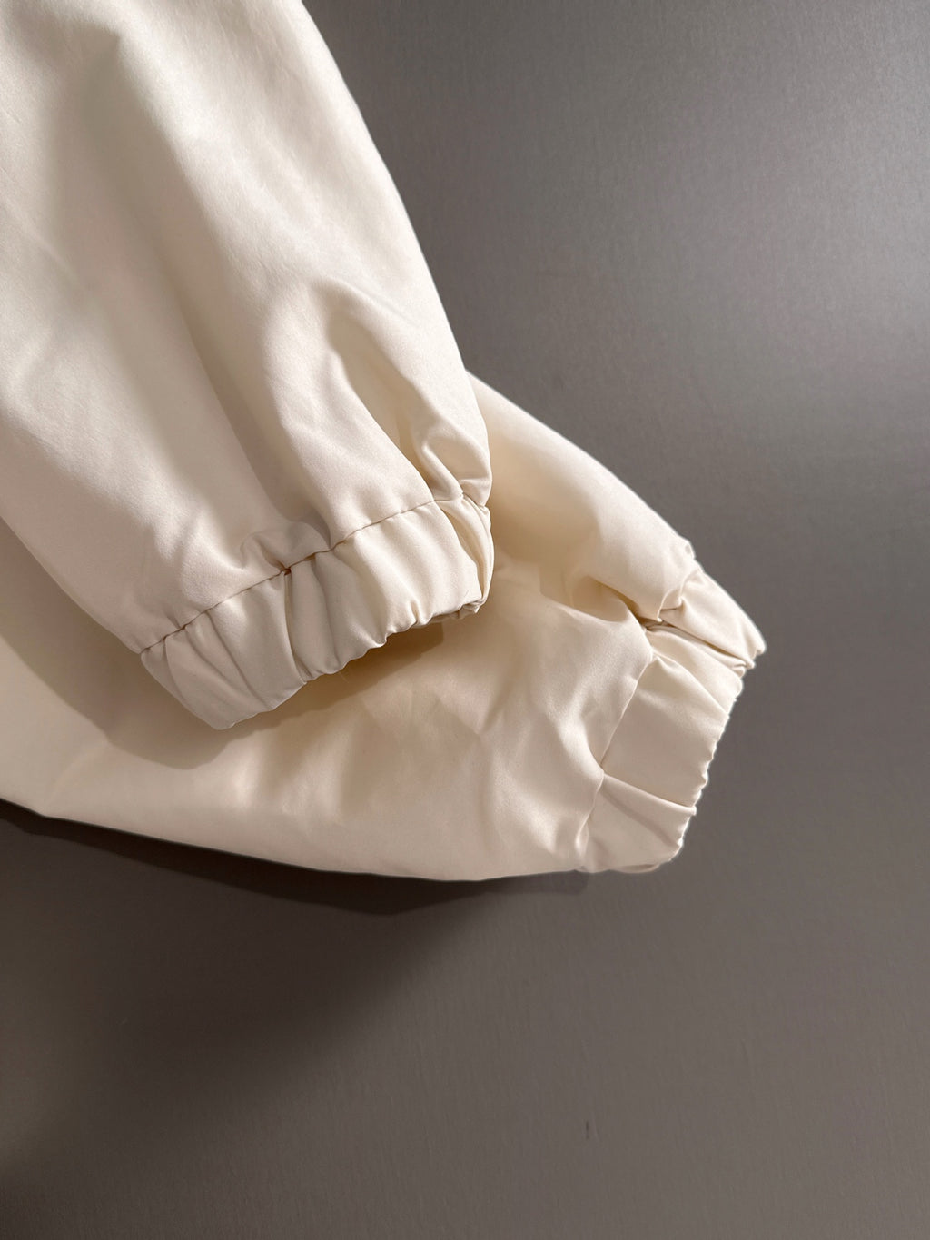 Off-white jacket sleeve with elastic cuff and gathered hem