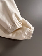 Off-white jacket sleeve with elastic cuff and gathered hem