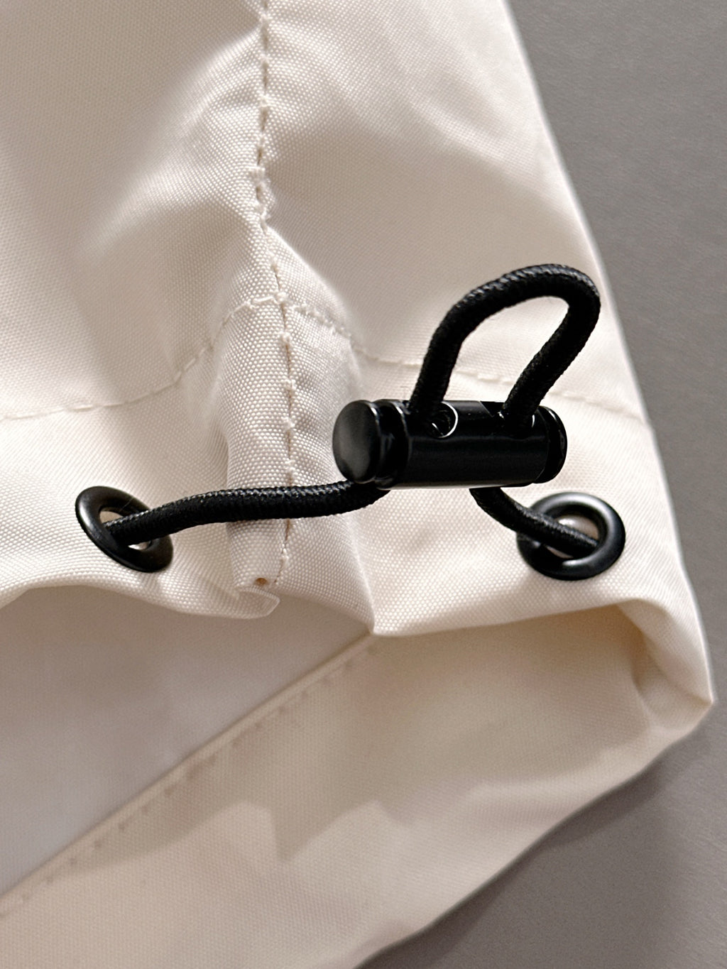 Off-white jacket hem with black drawstring and metal eyelets