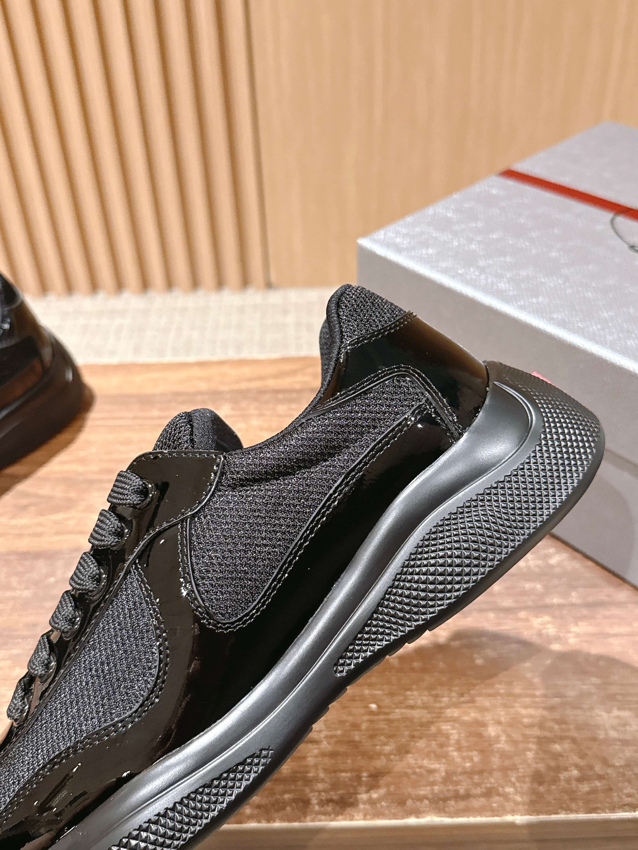 Black lace-up sneaker with dark mesh upper and rubber sole tread
