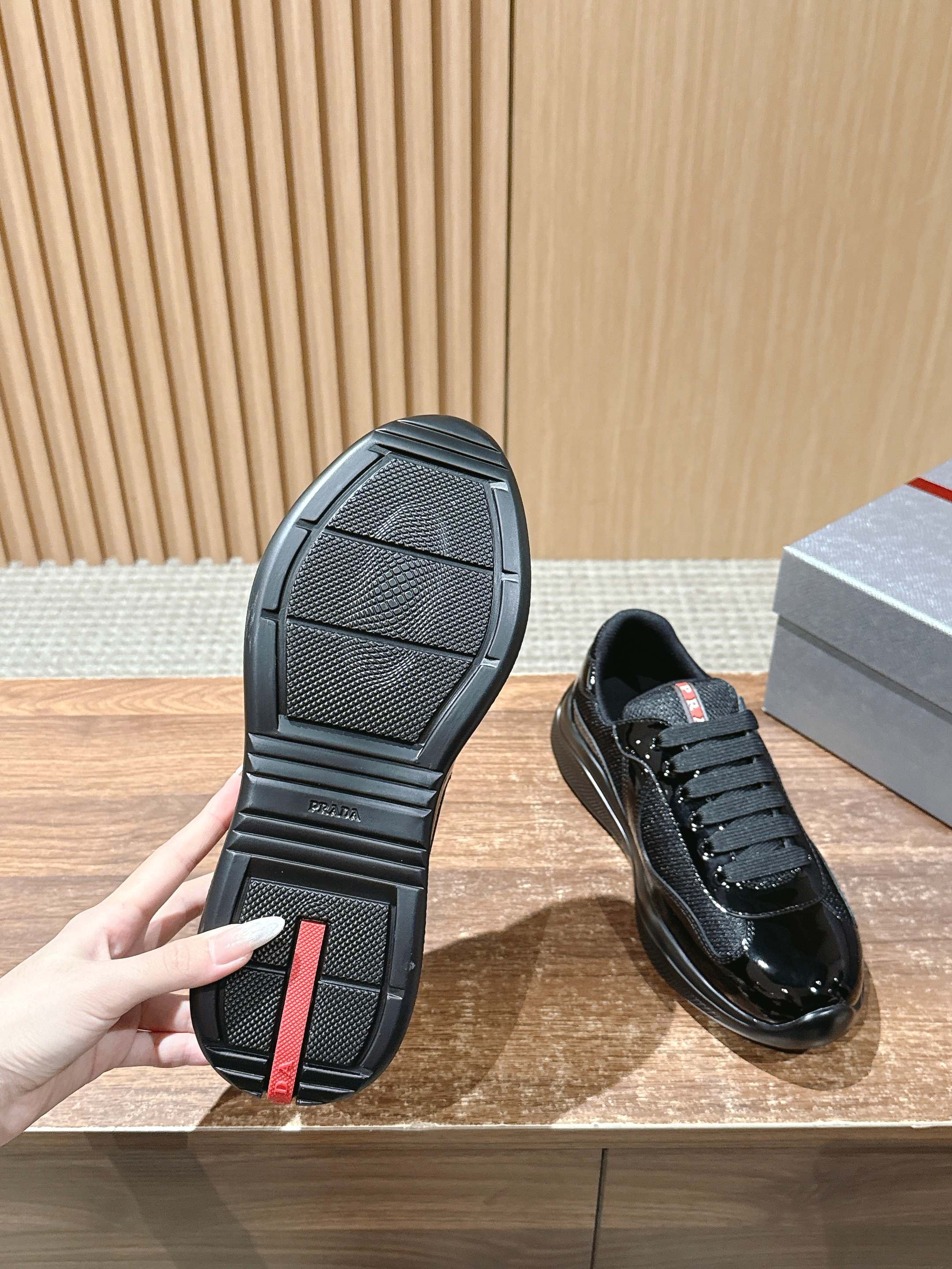 Black lace-up sneaker outsole view with textured rubber tread pattern