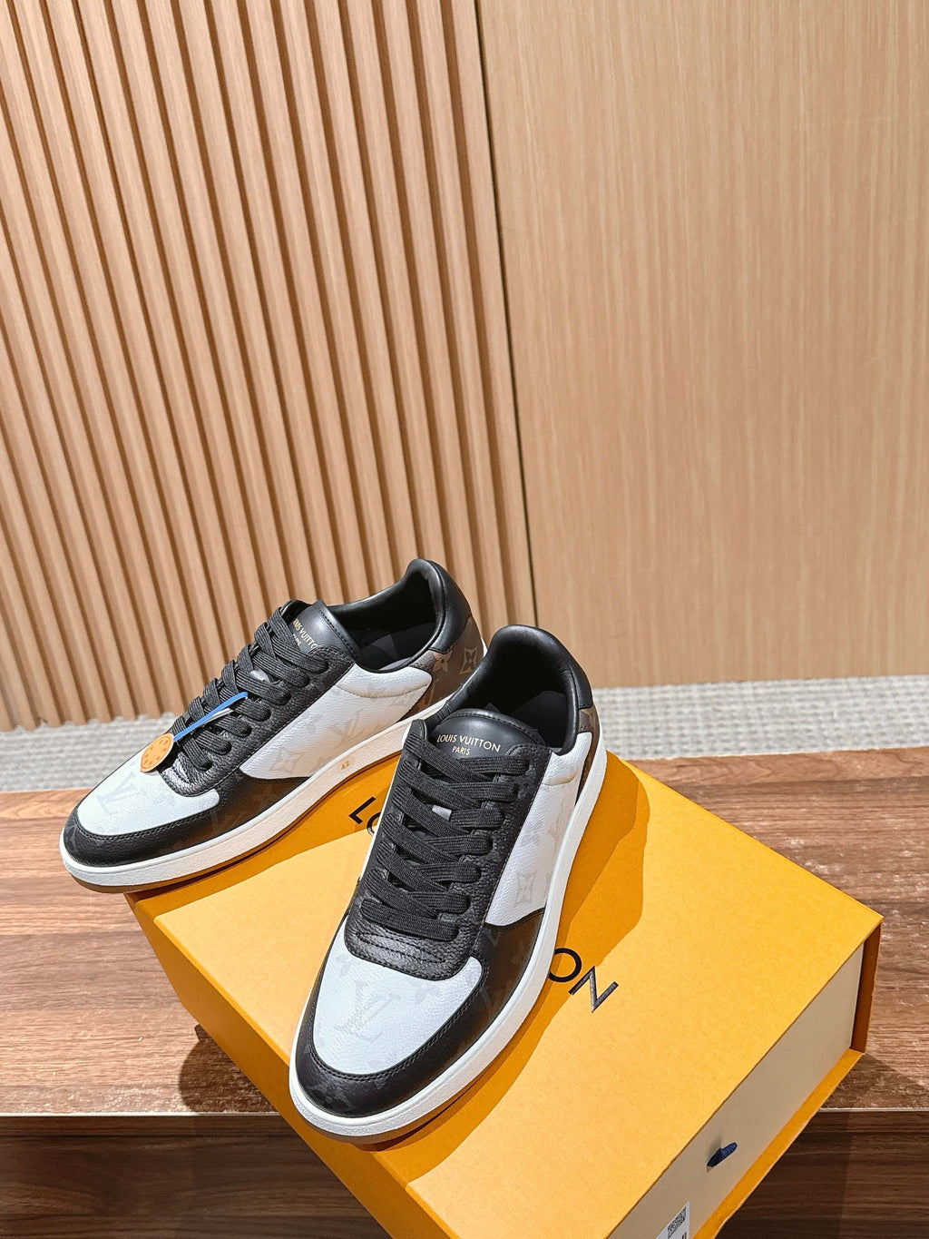 Low-top Louis Vuitton sneakers, black and white, lace-up front with stitched panels