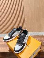 Low-top Louis Vuitton sneakers, black and white, lace-up front with stitched panels