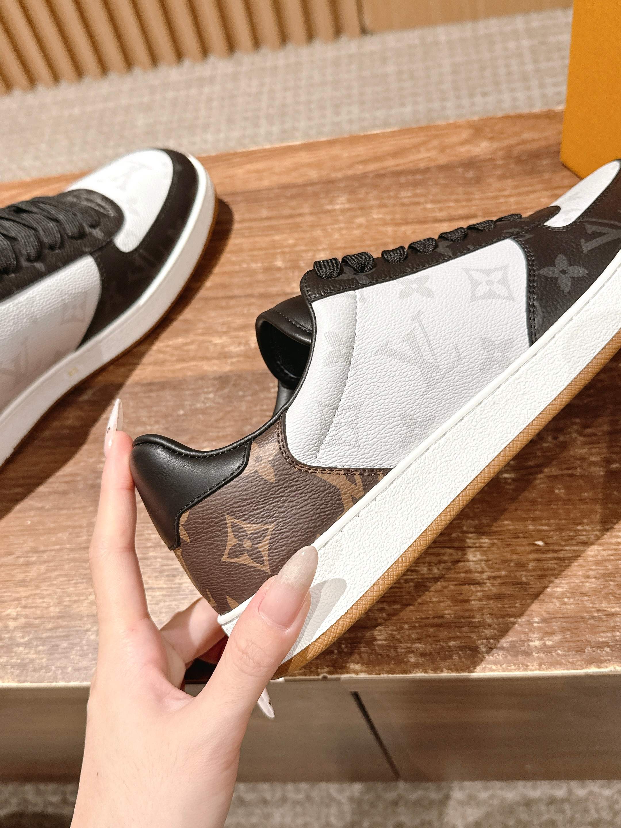 Louis Vuitton sneaker side, white-and-brown monogram panel with black lace-up upper