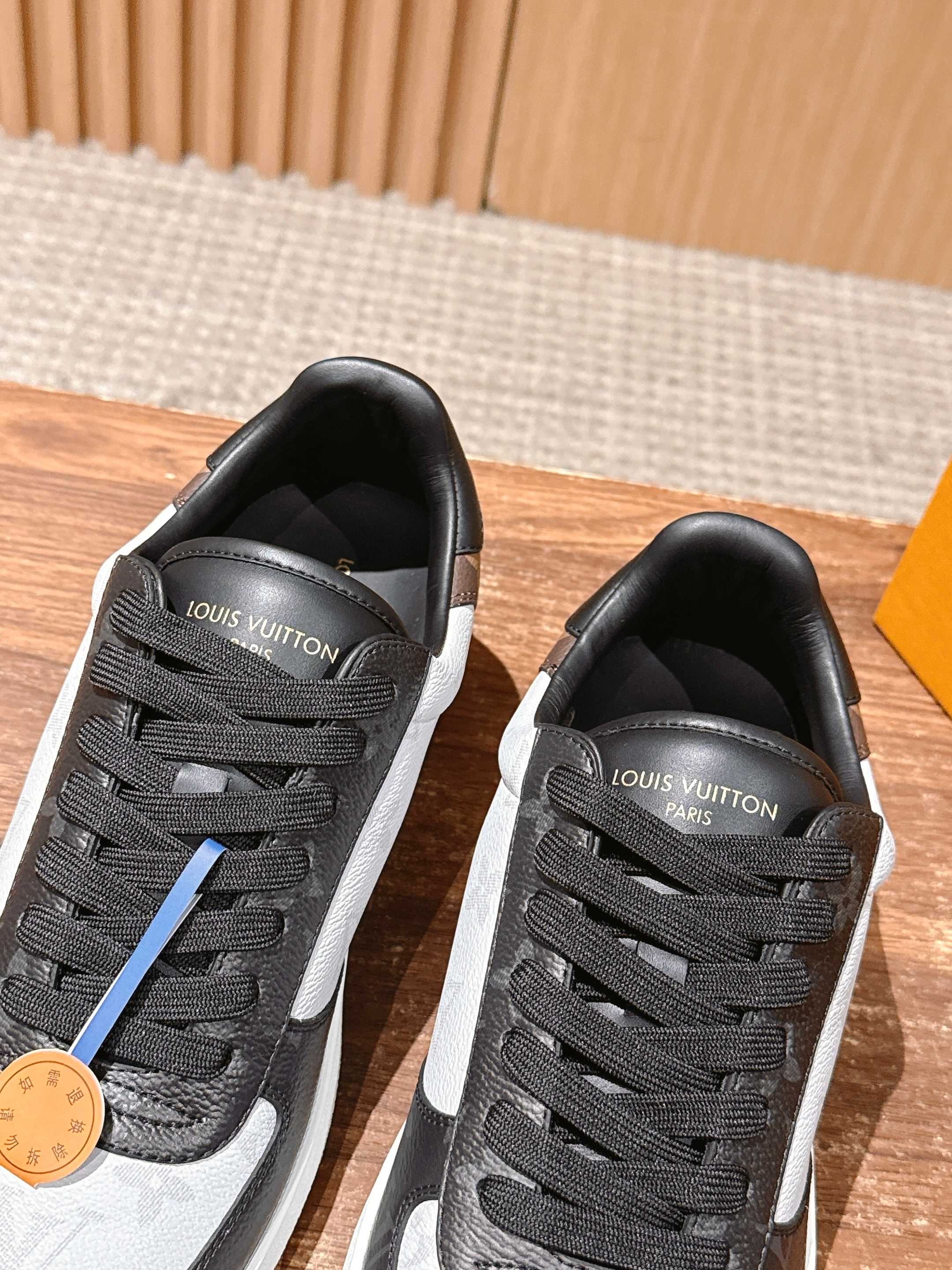 Louis Vuitton low-top sneakers, black-and-white uppers with blue stripe detail and laces
