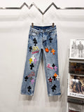 Light blue Chrome pants with colorful patch graphics and black cross motifs on legs