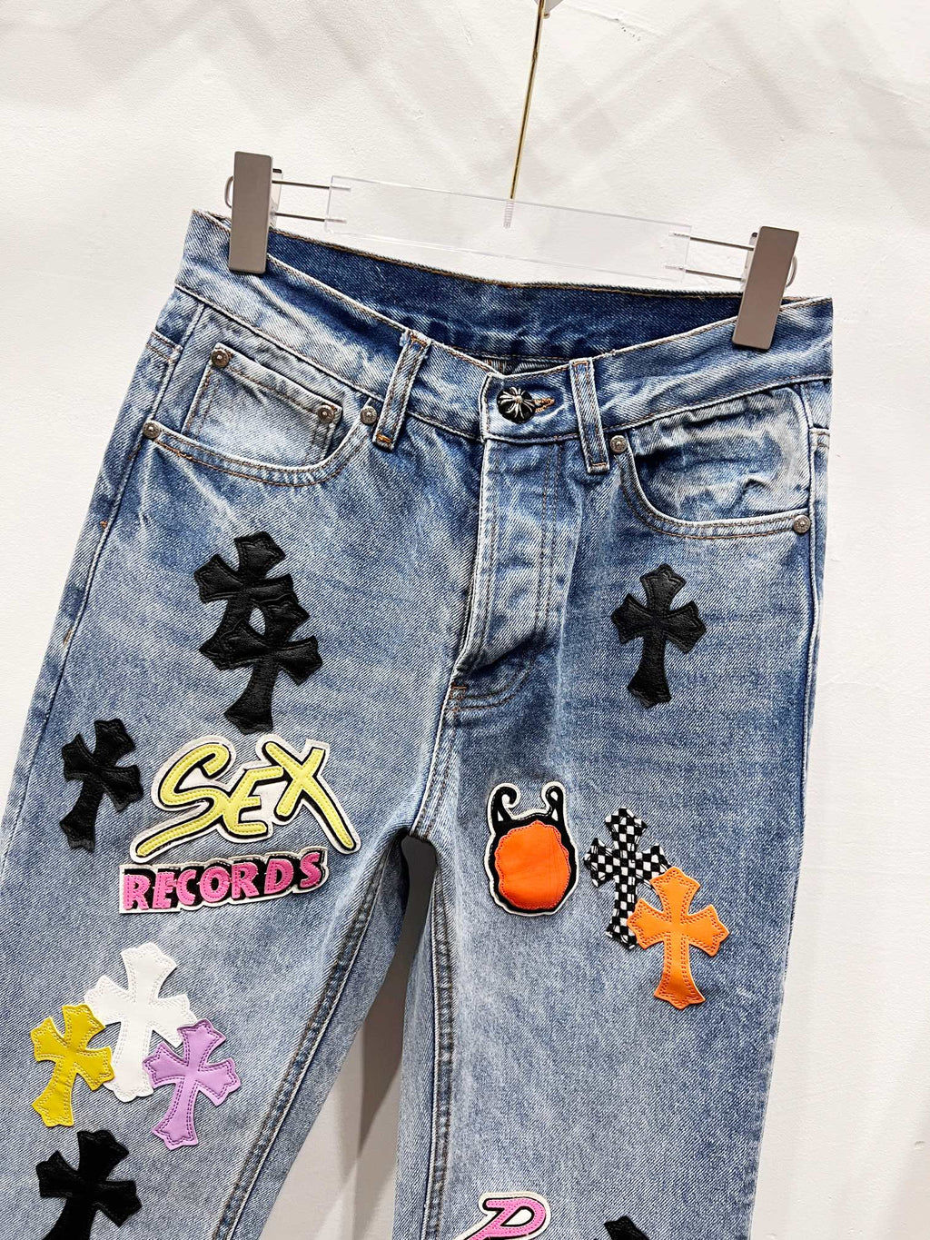 Light blue Chrome pants with black cross patches and embroidered logo graphic on front