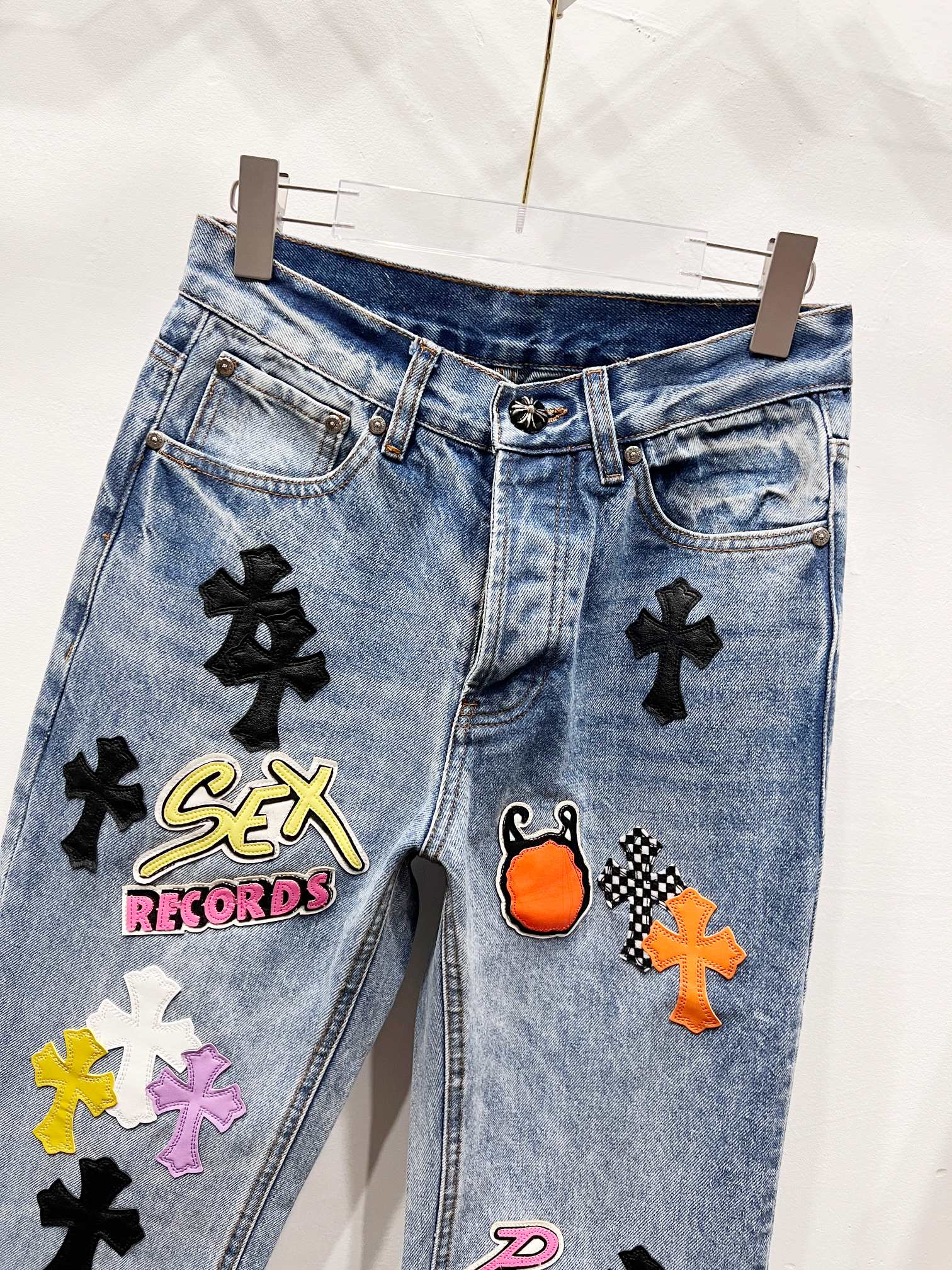 Light blue Chrome pants with black cross patches and embroidered logo graphic on front