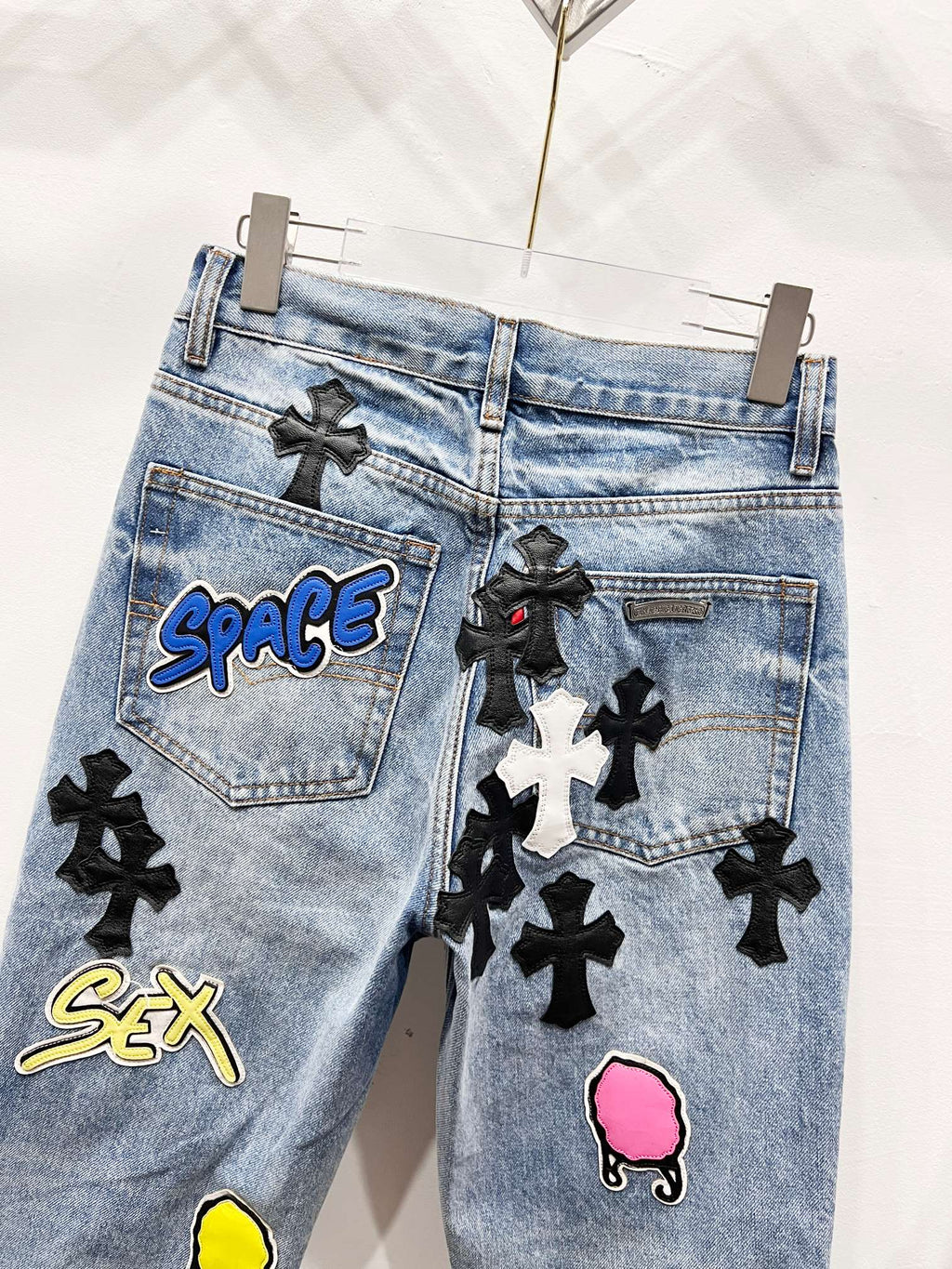 Light blue Chrome pants with black cross patches, pocket patch graphics, and pink face patch