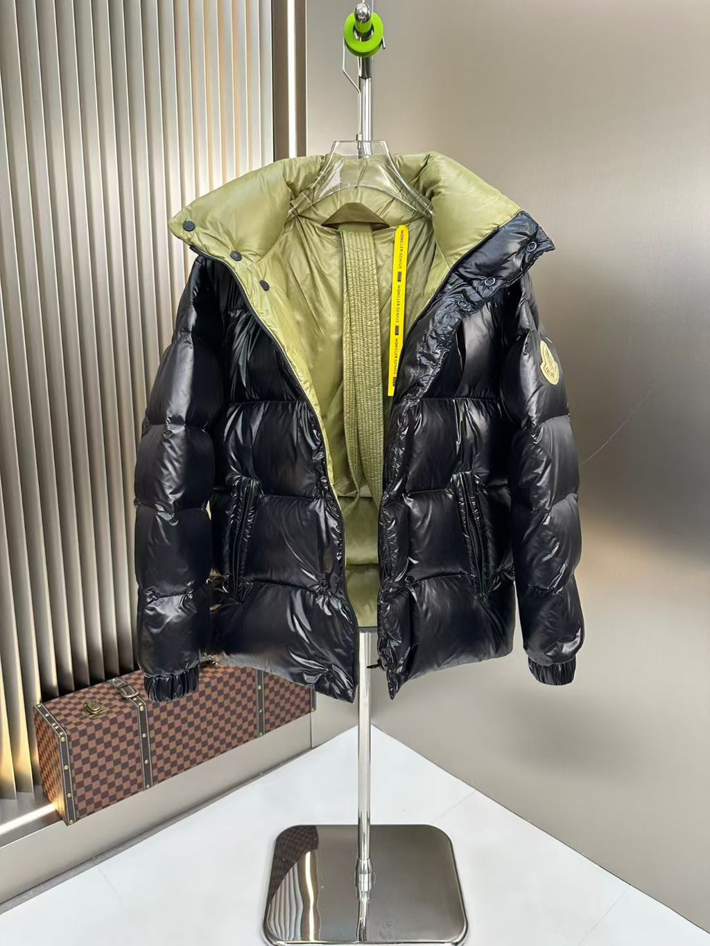 Long puffer jacket with black quilted sleeves and neon green hood overlay