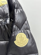Gold logo patch on black long puffer jacket sleeve cuff