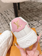 Louis Vuitton sneakers with pink tongue patch, gold LV logo, and molded side detail