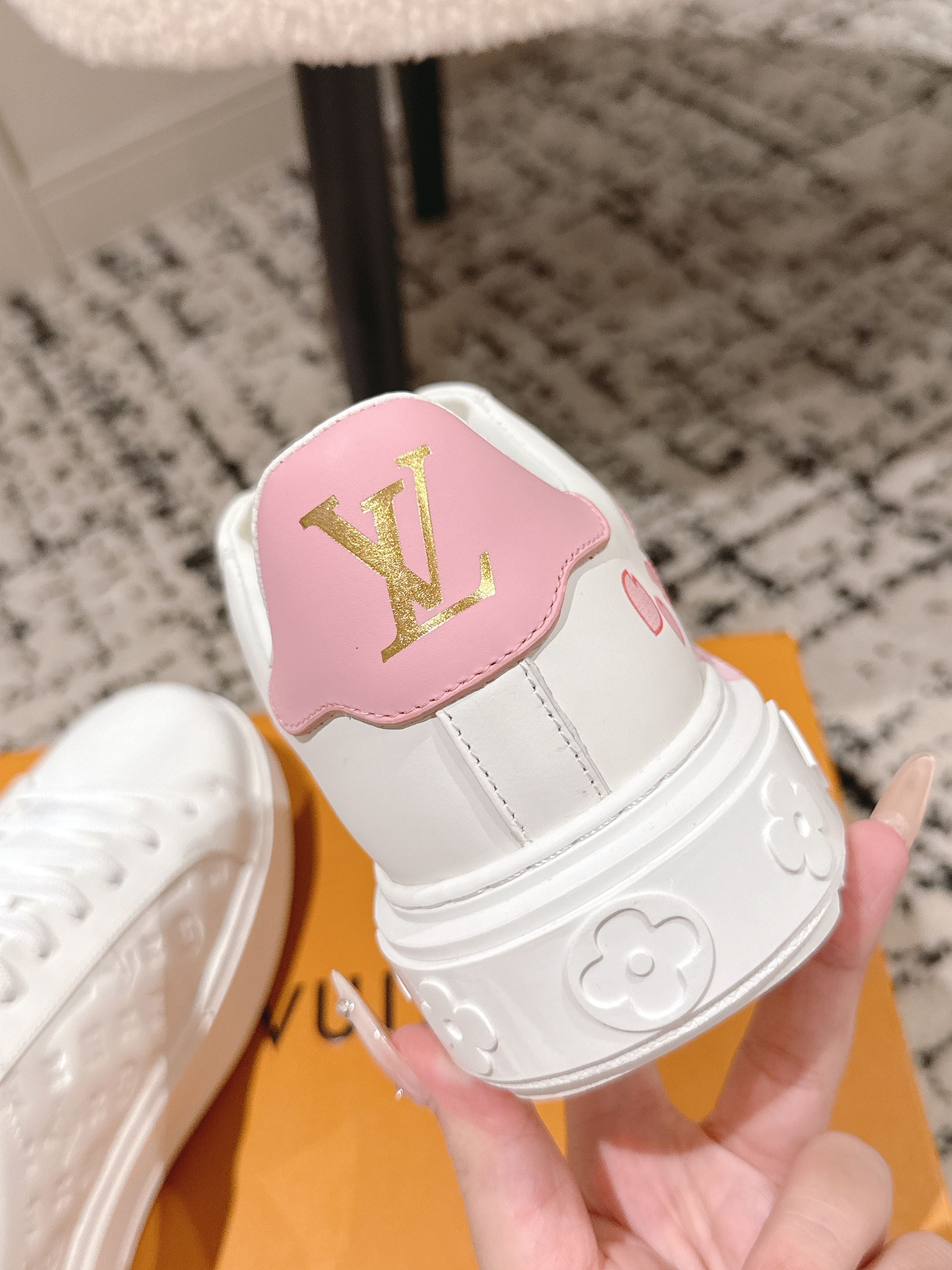 Louis Vuitton sneakers with pink tongue patch, gold LV logo, and molded side detail
