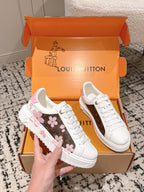 Louis Vuitton white low-top sneakers, one with pink floral side stripe