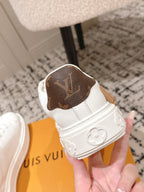 White low-top sneakers with dark monogram patch on heel and logo-pattern sole