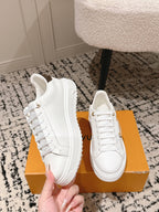 White lace-up low-top sneakers with dark-brown logo patch on the side