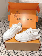 White lace-up low-top sneakers with embossed monogram and chunky rubber sole
