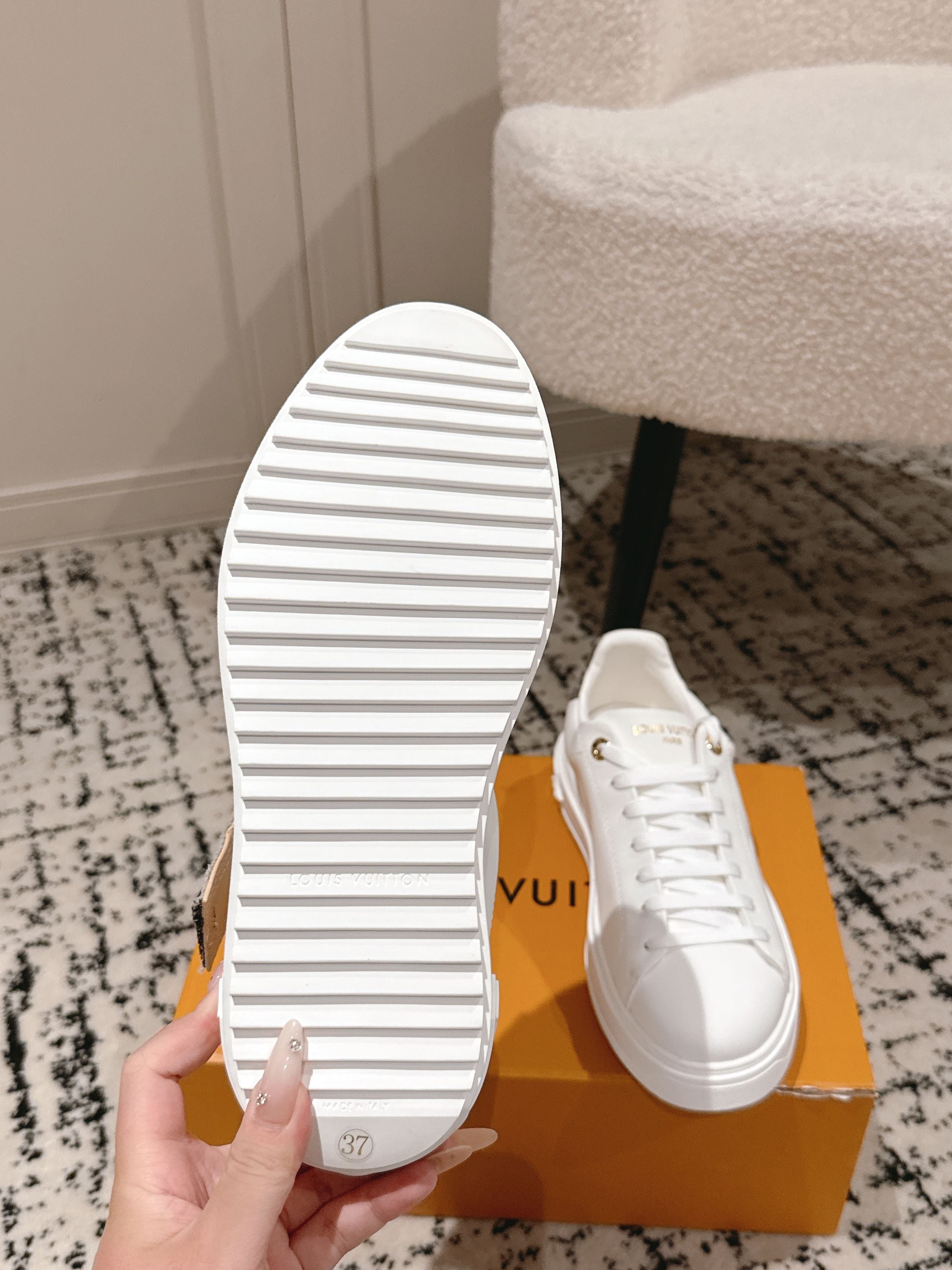 White sneakers outsole view with striped tread and lace-up upper