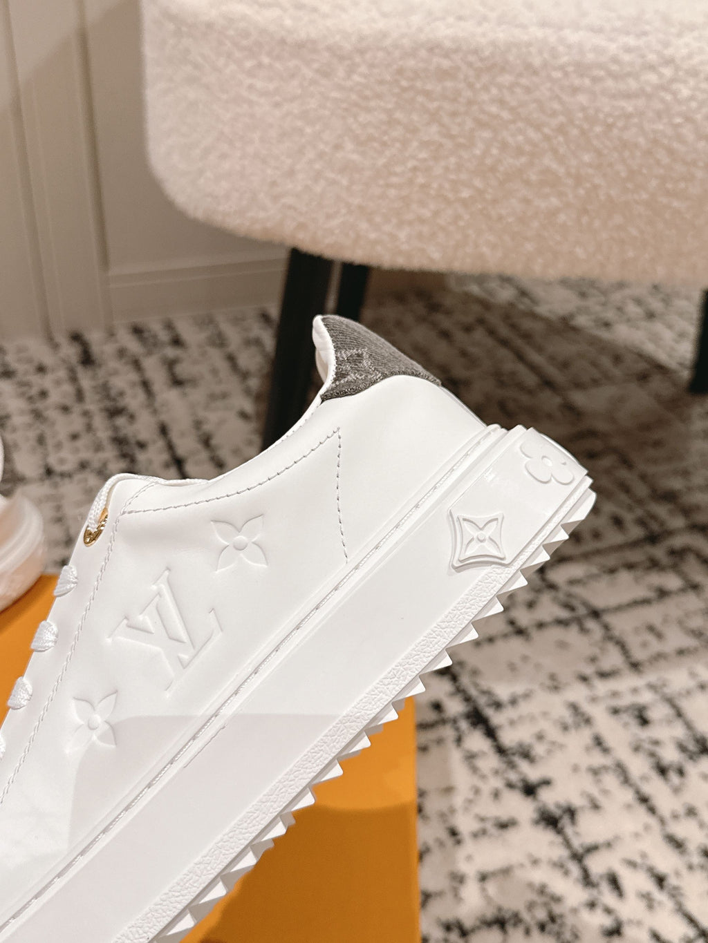 White sneakers with embossed monogram on the side and textured rubber sole